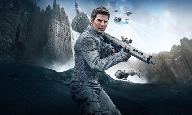 Tom Cruise wields a futuristic gun in Oblivion.