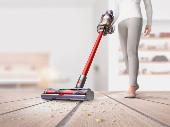 Woman vacuuming floor with Dyson V11 Outsize Total Clean Cordless Vacuum.