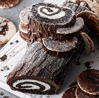 A chocolate log with a swirl of frosting on top

Description automatically generated